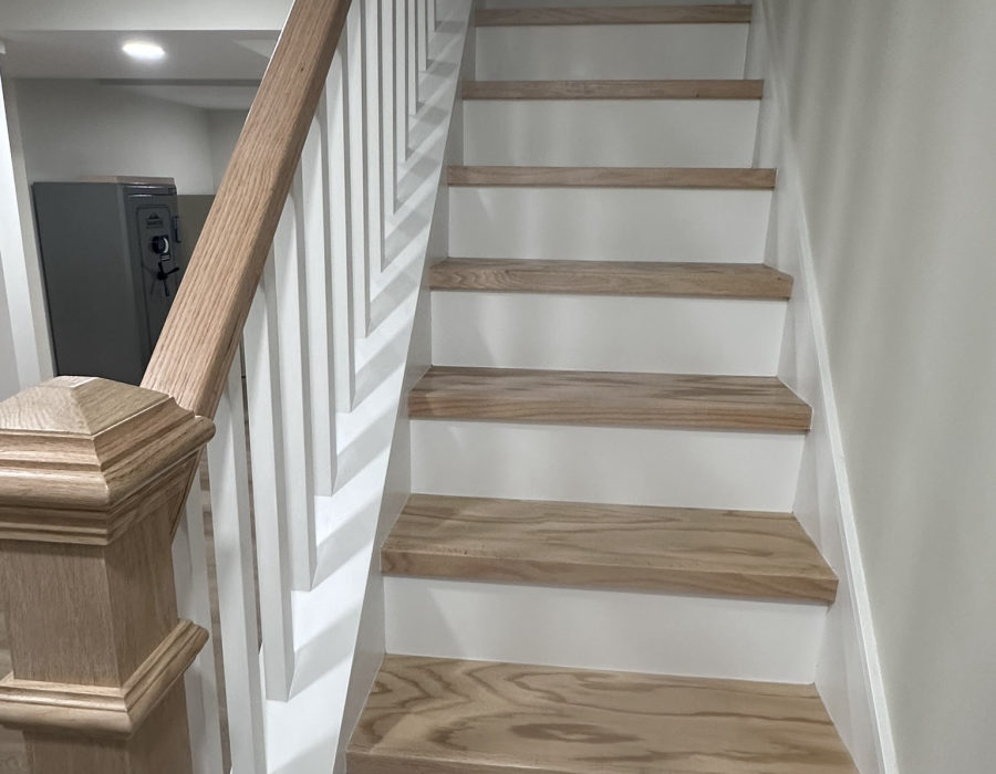 Finished basement living area with recessed lighting by Hamlett Renovations